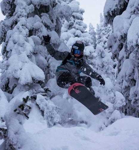 Un snowboarder realizando una maniobra en las pistas nevadas.