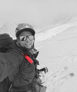 Montañista con Nomad Face Red Mars en entorno nevado, protector solar extremo SPF50+ para alta montaña.