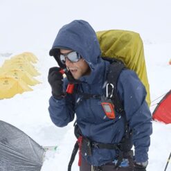 Alpinista aplicando Nomad Face Red Mars durante expedición nevada, protección solar sólida sin agua.
