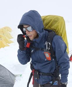 Alpinista aplicando Nomad Face Red Mars durante expedición nevada, protección solar sólida sin agua.