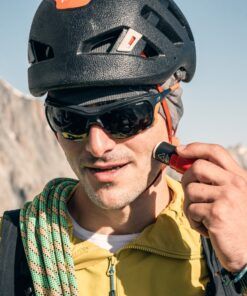 Escalador aplicando protector solar Nomad Face Red Mars, ideal para condiciones extremas en montaña.