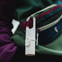 Bunker White Snow Nomad Face colgado en mochila de senderismo, protector solar mineral sostenible para actividades outdoor.