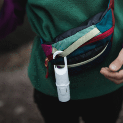 Bunker White Snow Nomad Face sujeto en riñonera, protector solar mineral para aventura y senderismo.