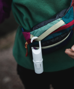Bunker White Snow Nomad Face sujeto en riñonera, protector solar mineral para aventura y senderismo.