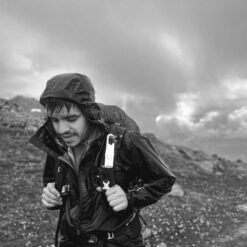 Excursionista con Nomad Face Bunker White Snow bajo la lluvia, protector solar extremo resistente al agua y viento.
