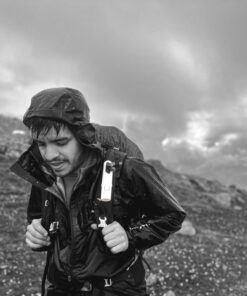 Excursionista con Nomad Face Bunker White Snow bajo la lluvia, protector solar extremo resistente al agua y viento.