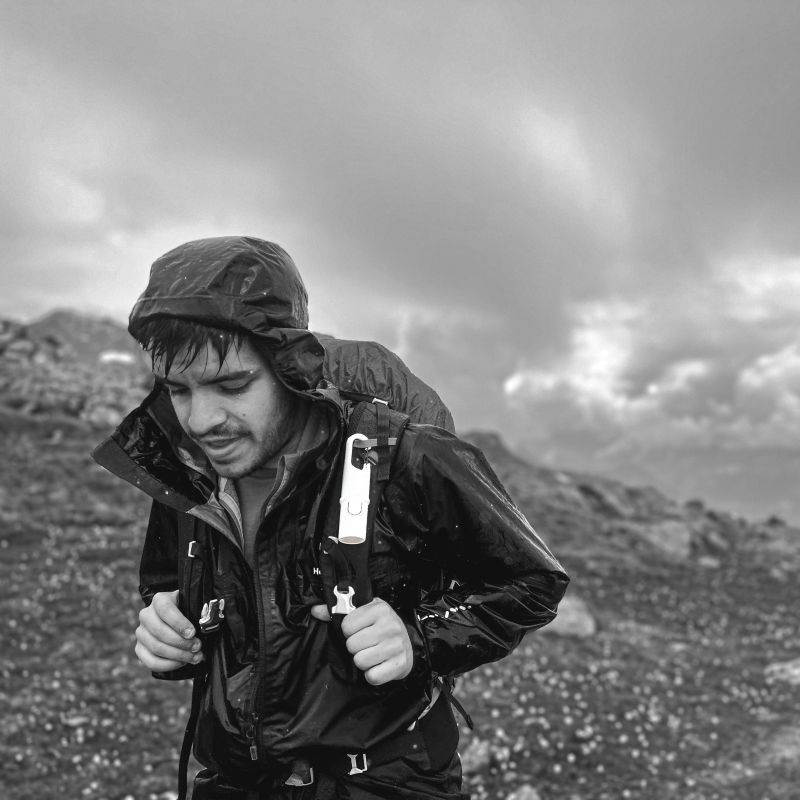 Excursionista con Nomad Face Bunker White Snow bajo la lluvia, protector solar extremo resistente al agua y viento.
