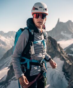 Alpinista con Nomad Face Bunker White Snow colgado en arnés, protector solar SPF50+ para alta montaña.