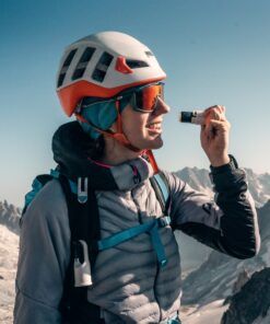 Escaladora aplicando Nomad Face White Snow protector solar en rostro, fórmula mineral sin agua.