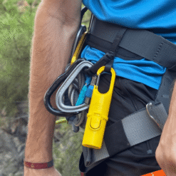 Nomad Face Yellow Sunrise – protector solar outdoor colgado en arnés de escalada, resistente al calor y al sudor.