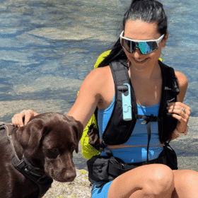 "Protector solar Nomad Face Blue Arctic – diseñado para deportistas, visible en el arnés de una excursionista junto a su perro."