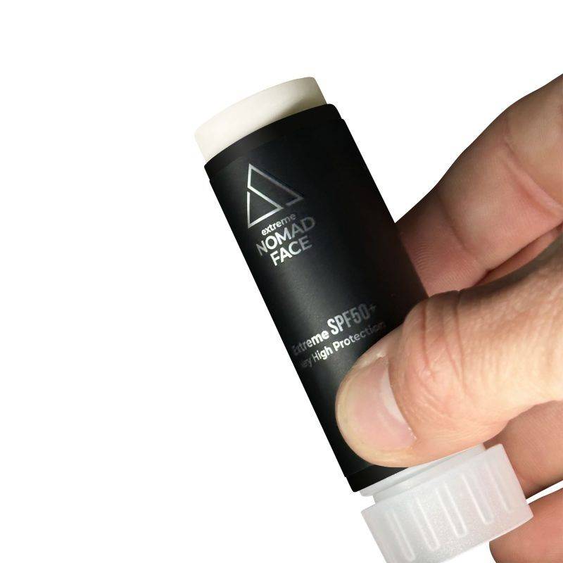 stick spf50+ mejor-proteccion-solar-facial Una mano sosteniendo un tubo negro de protector solar Nomad Face con factor de protección 50. El tubo está parcialmente abierto, mostrando la tapa blanca.