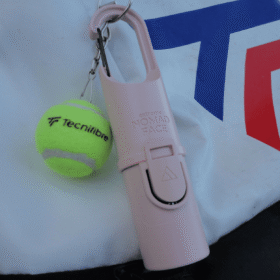 "Bunker Nomad Face Pink Quartz – protector solar extremo SPF50+ junto a pelota de padel, ideal para deportes al aire libre."