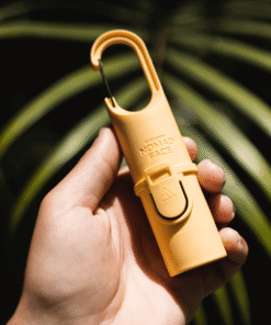 "Protector solar Nomad Face Bunker Yellow Sunset – envase técnico con clip mosquetón, ideal para alpinismo y aventuras outdoor."