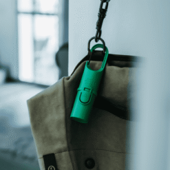 Protector solar Green Forest colgado en mochila, perfecto para uso diario en ciudad o escapadas rápidas.