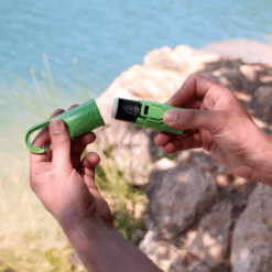 "Bunker Nomad Face Green Forest – cápsula y Bunker separados junto al agua, mostrando el sistema recargable y reutilizable."