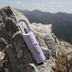 "Protector solar Nomad Face Bunker Purple Amethyst – colocado sobre una roca en alta montaña, preparado para condiciones extremas."