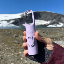 "Bunker Nomad Face Purple Amethyst – protector solar SPF50+ sostenido frente a un paisaje nevado, diseñado para resistir frío, viento y sol extremo."