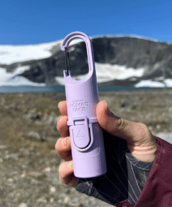 "Bunker Nomad Face Purple Amethyst – protector solar SPF50+ sostenido frente a un paisaje nevado, diseñado para resistir frío, viento y sol extremo."