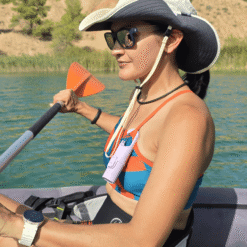 "Bunker Nomad Face Purple Amethyst – protector solar extremo SPF50+ usado en actividad náutica, colgado del cuello durante un paseo en kayak."