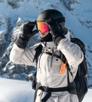 deportista en montaña con gafas protegiéndose del sol en invierno Escoger una proteccion solar para deportistas especificamente es clave