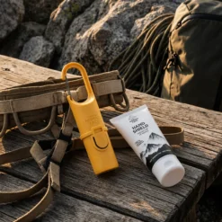 Pack Protección de Nomad Face con Full Kit SPF50+ y Hand Shield sobre una roca en un entorno outdoor.